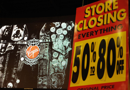 The board of 'store closing and discount' blares at the Virgin Megastore in Times Square in New York, the United States, March 29, 2009. The store will be closed on Monday. All the other five Virgin Megastores in New York are set to close before this summer. There were once 23 retail locations based in the United States. The physical CD retails witnessed smashing challenge from the digital download music market, the analysts said.[Xinhua]