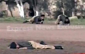 This television frame grab from NDTV shows Pakistani policemen trying to take cover as a body is seen in the foreground in Lahore on March 30 after gunmen attacked a police training school.[CCTV/AFP/NDTV] 