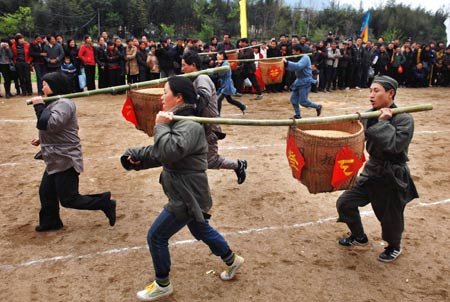 People take part in a contest of carrying cereals at the farming cultural festival held in Suichang County, east China's Zhejiang Province, March 30, 2009. 