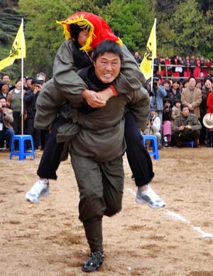 A farmer runs during the contest of carrying 'bride' at the farming cultural festival held in Suichang County, east China's Zhejiang Province, March 30, 2009.