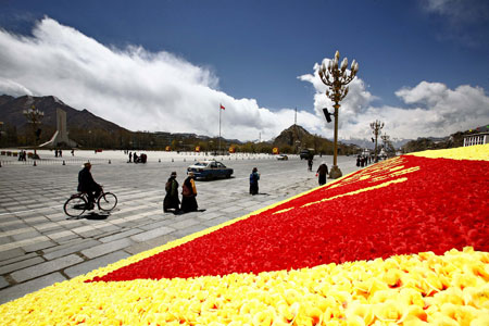 People walk on the flower-decorated square in front of the Potala Palace bathed in spring sunshine in Lhasa, southwest China's Tibet Autonomous Region, March 31, 2009. The city of Lhasa is welcoming the spring season. (Xinhua/Zhang Quan)