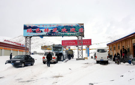 Vehicles stop at the entrance of Mila Mountain in Nyingchi, southwest China's Tibet Autonomous Region, March 31, 2009. 