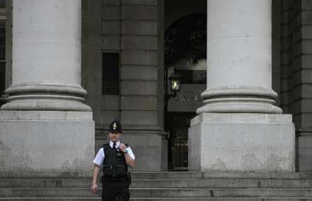 A policeman stands guard in front of the building of the Royal Exchange in London March 31, 2009. A suspected package was found near the building of the Royal Exchange on Tuesday. Police sealed off the area, but shortly afterwards an all clear order was given.