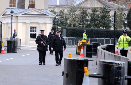 Armed policemen patrol on a closed road beside the Winfield House, the official residence of the United States ambassador to Britain where U.S. President Barack Obama will stay during the summit of the Group of 20 Countries (G20), in London on March 31, 2009.