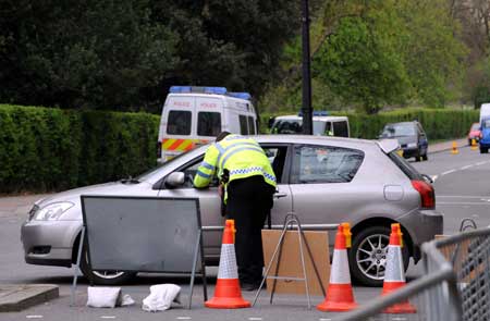 A policeman checks a car on a closed road beside the Winfield House, the official residence of the United States ambassador to Britain where U.S. President Barack Obama will stay during the summit of the Group of 20 Countries (G20), in London on March 31, 2009.