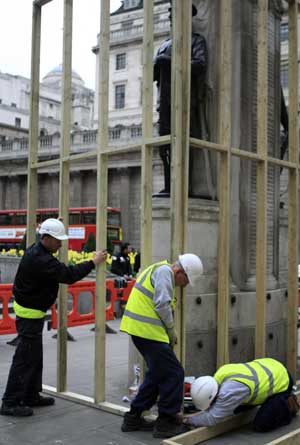 Workers place battens around a war memorial statue outside the building of the Royal Exchange in London March 31, 2009. The British capital is bracing for protests before and during the summit of the Group of 20 Countries, to be held on April 2. 