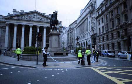  Police officers work in front of the building of the Royal Exchange in London March 31, 2009. A suspected package was found near the building of the Royal Exchange on Tuesday. Police sealed off the area, but shortly afterwards an all clear order was given. London police have tightened security for the summit of the Group of 20 Countries to protect the meeting from possible violent protests. [Xinhua]