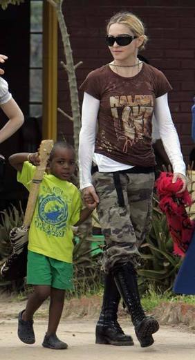 U.S. pop star Madonna walks while holding her adopted Malawian son David Banda at a school she financed, some 50 km south of Malawi's capital Lilongwe, March 30, 2009.