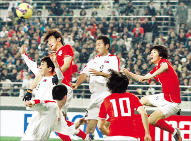 North Korea's Pak Chol-jin and South Korea's Hwang Jae-won (top) go for a header as North's Jong Taese (center) and South's Kang Min-soo also get into the act during a World Cup qualifier. [Shanghai Daily]