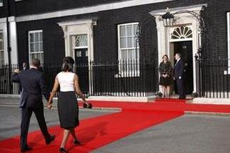 President Barack Obama and first lady Michelle Obama walk on the red carpet to be greeted by British Prime Minister Gordon Brown, and his wife Sarah Brown at Number 10 Downing Street in London, Wednesday, April 1, 2009, for the G-20 working dinner. [Pablo Martinez Monsivais/AP Photo] 
