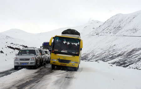 Vehicles struggle with snow and ice on a highway linking Tibet with the neighboring province of Sichuan in Nyingchi, southwest China's Tibet Autonomous Region, March 31, 2009. [Ye Hui/Xinhua] 