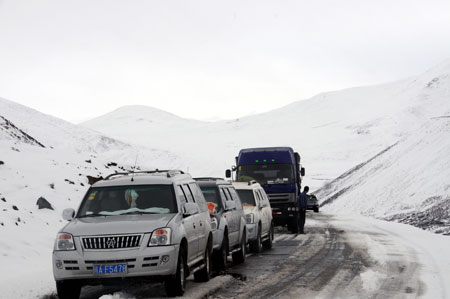 Vehicles queue at the Mila Mountain section of a highway linking Tibet with the neighboring province of Sichuan in Nyingchi, southwest China's Tibet Autonomous Region, March 31, 2009. [Ye Hui/Xinhua]