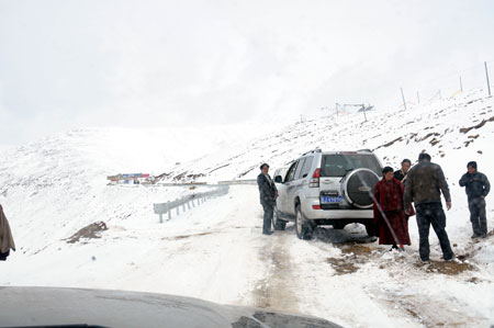 A vehicle stops by the roadside on a highway linking Tibet with the neighboring province of Sichuan in Nyingchi, southwest China's Tibet Autonomous Region, March 31, 2009. Because of continuous snowfall, the road condition at the Mila Mountain section of the highway became tough and difficult for vehicles. [Ye Hui/Xinhua] 