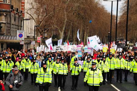 British police wearing fluorescent jackets keep order in front of a group of protesters in London, Britain, March 28, 2009. 