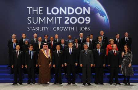 Chinese President Hu Jintao (4th L, 1st row), and other leaders attending the Group of 20 summit, and top officials from relevant organizations pose for group photos in London, Britain, April 2, 2009. [Xinhua]