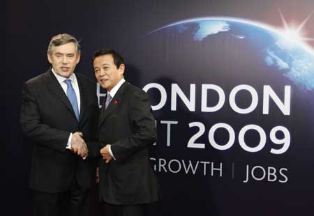 Prime Minister of Japan Taro Aso (R) arrives at ExCel center and is greeted by British Prime Minister Gordon Brown for the summit of the Group of 20 Countries (G20) in London April 2, 2009. [Xinhua]