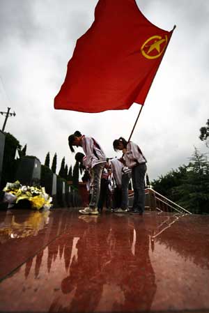 Chinese middle school students make a bow to pay their respects to deceased heroes at a local cemetery for revolutionary martyrs in Suining, southwest China's Sichuan province, April 2, 2009, two days prior to the Qingming festival, or the tomb sweeping day, that falls on April 4.