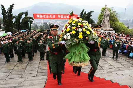 Chinese armed police soldiers present flowers at a ceremony to pay their respects to deceased heroes at a local cemetery for revolutionary martyrs in Pingxiang City, south China's Jiangxi Province, April 2, 2009, two days prior to the Qingming festival, or the tomb sweeping day, that falls on April 4.