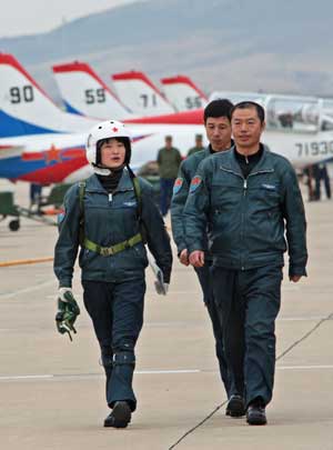 Pilot trainee Yu Xu (L) walks with coaches after a flight test in China, March 29, 2009. China's first batch of female jet fighter pilots were conferred the rank of lieutenant on April 2. 