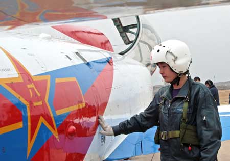 Pilot trainee Tao Jiali examines a jet fighter before her flight test in China, March 29, 2009. China's first batch of female jet fighter pilots were conferred the rank of lieutenant on April 2. 