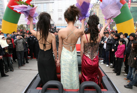Models and luxury cars attract lots of local citizens in Luoyang, central China's Henan Province, April 2, 2009. A motorcade consisting of luxury cars toured around Luoyang city on Thursday to greet the eighth luxury car show opened on April 3. (Xinhua/Li Shubao) 