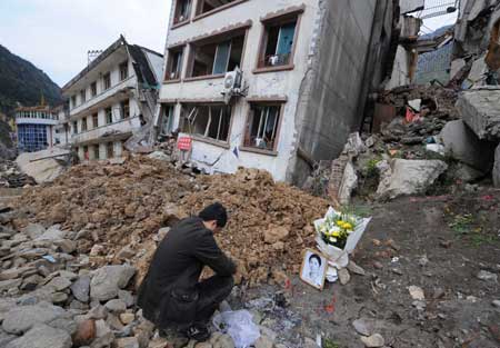 Li Yang (R1), a student from Beichuan Middle School and also a survivor from the devastating earthquake striking southwest China's Sichuan Province May 12, 2008, mourns the earthquake victims at the ruins of Beichuan Middle School in Beichuan County, southwest China's Sichuan Province, April 4, 2009. Li arrived here early Saturday, the traditional Qingming Festival or Tomb-sweeping Day, to mourn his teachers and classmates killed by last year's earthquake.