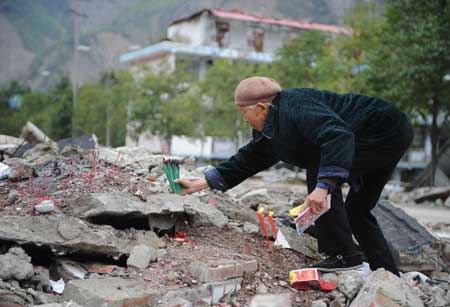 An aged woman mourn her relatives killed during the devastating earthquake striking southwest China's Sichuan Province May 12, 2008, in Beichuan County, southwest China's Sichuan Province, April 4, 2009. Beichuan County, one of the most seriously hit areas by last year's dissolving earthquake, opened to the public in recent days for the traditional Qingming Festival or Tomb-sweeping Day. 