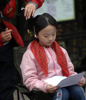 Lin Miaoke, the girl who performed at the opening ceremony of Beijing 2008 Olympic Games, reads the play book of the new version of TV play 'A Dream of Red Mansions' in Yangzhou, east China's Jiangsu Province, April 3, 2009. This is the first time for her to act in the play.