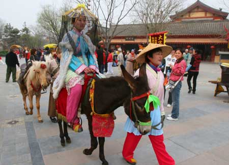A Chinese woman in trational costumes rides a donkey to showcase the life of China's Northern Song Dynasty (960-1126 A.D.) at a tourism promotional initiative during the Qingming festival, or the Tomb-sweeping Day, in Kaifeng city, central China's Henan Province, April 4, 2009. [Xinhua]