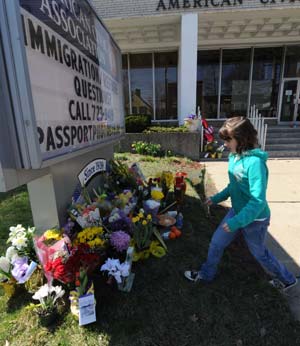 A girl offers flowers to mourn for victims killed in Friday's shooting rampage at the American Civic Association in Binghamton, the United States, on April 5, 2009. A total of 14 people of eight different countries of origin were killed in Friday's deadly shooting rampage in downtown Binghamton. [Xinhua]