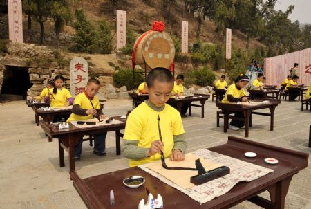  Kids show their calligraphy while taking part in the ceremony to commemorate Confucius, at the Confucian temple in Qufu, east China's Shandong Province, April 4, 2009. [Xinhua]