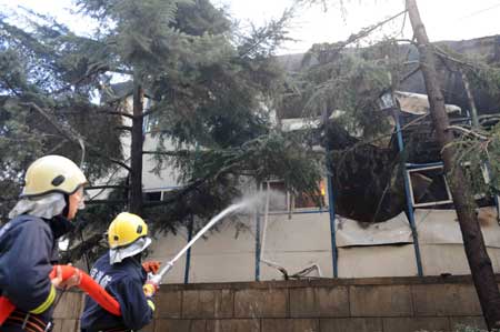 Fire fighters work at the site where a fire breaks out at a dormitory of migrant workers near Wanshoulu in western Beijing, China, April 6, 2009. There's no casualty reported at present. (Xinhua/Wen Tao)