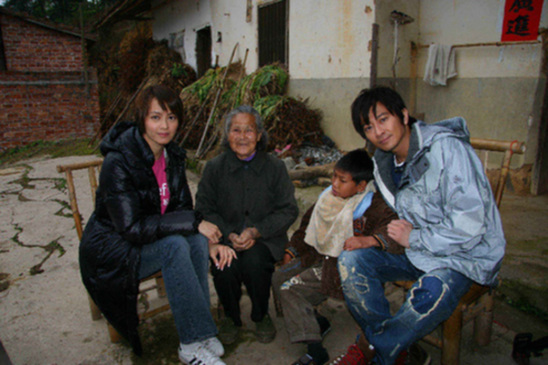Gigi Leung (1st L) and Eric Suen, the Hong Kong Committee for UNICEF ambassador and special representative respectively, visit a child and his grandma in rural Jiangxi Province. The UNICEF Jiangxi trip lasted for a week, from March 31 to April 5. [UNICEF]