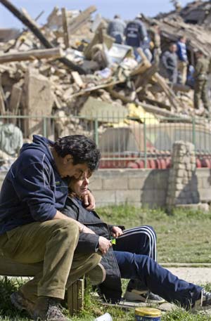 A couple embrace near the ruins of their house after an earthquake in the Italian village of Onna April 6, 2009. A powerful earthquake struck a huge swath of central Italy as residents slept on Monday morning, killing at least 100 people when thousands of houses, churches and other buildings collapsed or were damaged. 