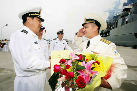 Xing Yuqi (L), an officer of South China Sea Fleet of the Navy of the Chinese People's Liberation Army (L) welcomes a visiting officer of Russian navy at the port of Zhanjiang, south China's Guangdong Province, April 6, 2009. 