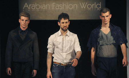 Designer Omar Kashoura (C) with 2 of his models after his show during Arabian Fashion World, in London April 6, 2009.