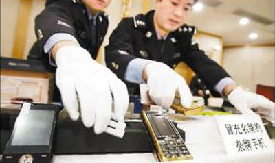 Beijing police check the products they confiscated from a slew of telemarketing gangs recently. [China Daily] 