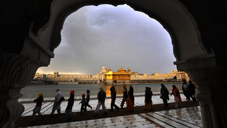 Tourists and Sikhs walk at the Golden Temple in Amritsar, India, April 7, 2009. The temple is the holiest shrine for Sikhs.(Xinhua/Wang Ye)