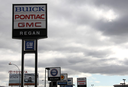 A placard of General Motors (front) is seen at a car dealership in New York, the United States, April 7, 2009. The time-honored General Motors Corp is on the brink of bankruptcy. (Xinhua/Liu Xin)
