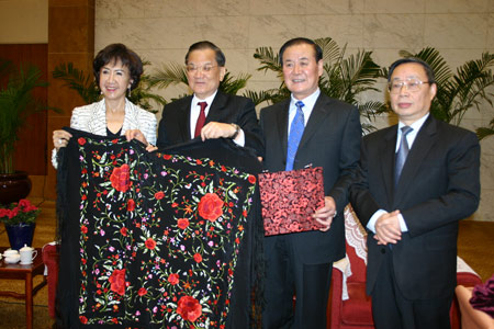 Shi Zongyuan (2nd R), the Communist Party Chief of Guizhou, gives a present to Kuomintang Honorary Chairman Lien Chan (2nd L) on behalf of Guizhou Province, in Guiyang, southwest China's Guizhou Province, on April 8, 2009. A delegation headed by Lien Chan arrived here on Wednesday for a visit to the province. (Xinhua/Wang Li)