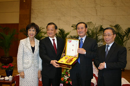 Shi Zongyuan (2nd R), the Communist Party Chief of Guizhou, gives a present to Kuomintang Honorary Chairman Lien Chan (2nd L) on behalf of Guizhou Province, in Guiyang, southwest China's Guizhou Province, on April 8, 2009. A delegation headed by Lien Chan arrived here on Wednesday for a visit to the province. (Xinhua/Wang Li)