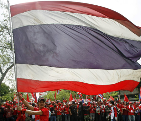 A supporter of former Thai Prime Minister Thaksin Shinawatra waves a Thai flag during rally to the home of Prem Tinsulanonda, chief adviser to King Bhumibol Adulyadej, which is near Government House in Bangkok April 8, 2009. (Xinhua/Reuters Photo)