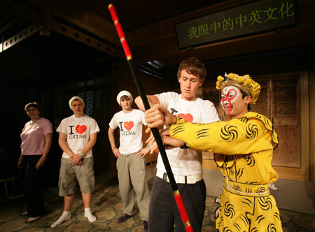 A British middle school student learns how to play the 'Jingubang', a stage property, from an actor of Kunqu Opera in Suzhou city of east China's Jiangsu Province, April 8, 2009. Over thirty British middle school students visited China Kunqu Opera Museum in Suzhou on Wednesday and learned impromptu some skills of Kunqu performance, when they were on cultural exchange visits to Suzhou Foreign Languages School. 