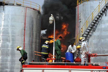 Firefighters hose down the fire at No.1 and No.2 light oil tanks of coal-to-liquids (CTL) projects base of Yitai Group in northwest China's Inner Mongolia Autonomous Region, April 8, 2009. The fire was put out at about 4:10 pm of the day without casualties and crucial production equipments loss. (Xinhua/Zhang Ling)