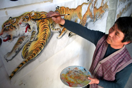 Wang Demin, a farmer fond of painting, colors his tiger painting at home in Tancheng County of east China's Shandong Province, April 8, 2009. Wang started to paint tigers this January and has finished 68 pieces of tiger pictures as he planed to make a hundred pieces before China's National Day on this Oct. 1st. (Xinhua/Zhang Chunlei)