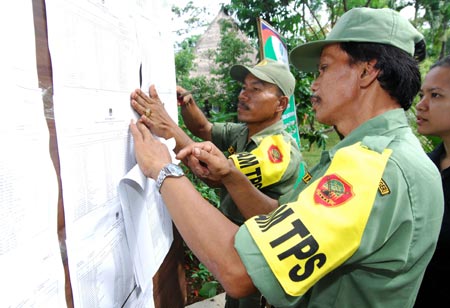 Security members check a voting bulletin at a polling station in Bogor on the outskirts of Jakarta, capital of Indonesia, on April 9, 2009. (Xinhua/Yue Yuewei)