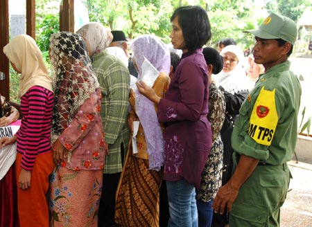 A security member (R) stands guard at a polling station in Jakarta, capital of Indonesia, on April 9, 2009. Voting started Thursday morning in Indonesia's legislative elections as voters are moving to polling stations to cast votes for their representatives in the parliament. Nearly 250,000 security members are dispatched to nearly 530,000 polling stations across the country to ensure a smooth process of the legislative elections. (Xinhua/Yue Yuewei)