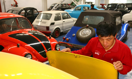 Luo Wenyou, a collector of classic cars, arranges one of his collection in his classic car museum in Beijing, April 9, 2009. (Xinhua/Bu Xiangdong) 