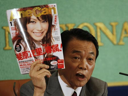 Japan's Prime Minister Taro Aso shows a magazine as he talks about a policy boosting cultural activities at a news conference in Tokyo April 9, 2009.(Xinhua/Reuters Photo)