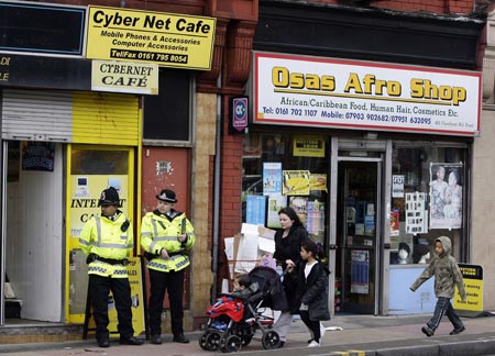 British police officers guard an internet cafe in Manchester, northern England April 9, 2009. 